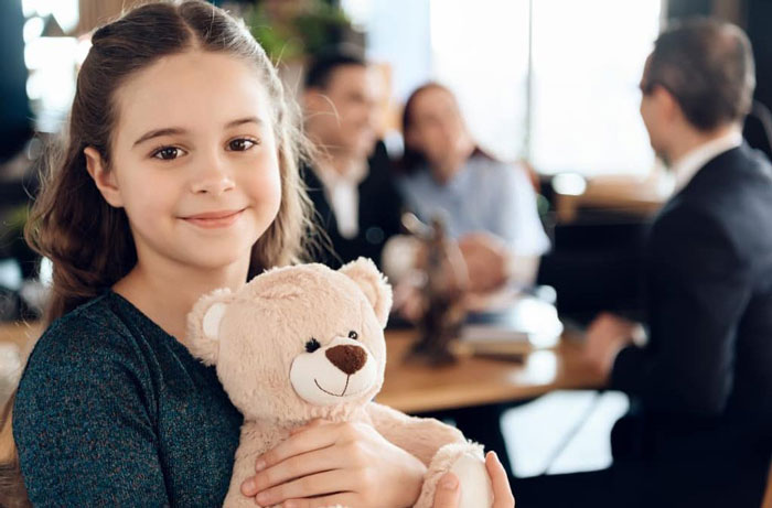 A smiling Kid holding teddy bear in hand