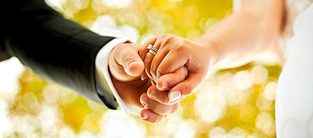 A married couple holds hands.