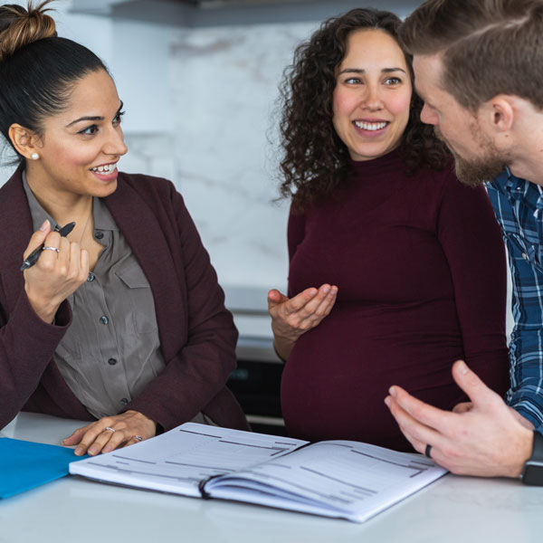pregnant couple signing paperwork