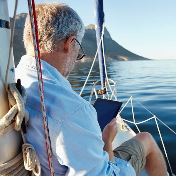 man using a tablet on a boat